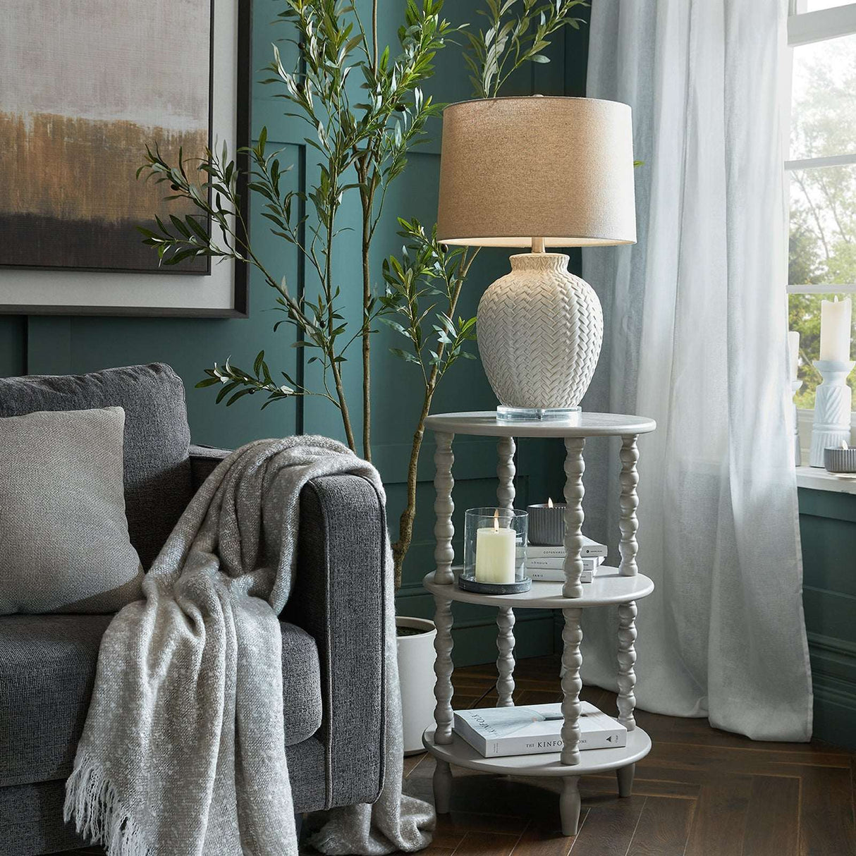 Stylish Shades 4 Seasons side table with two tiers and decorative lamp in a modern living room setting