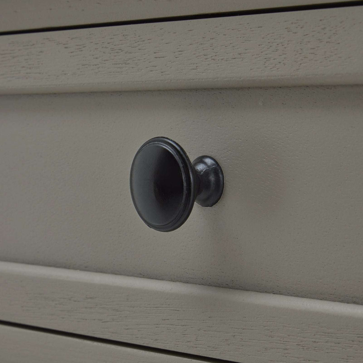 Close-up of a black knob on a Shades 4 Seasons side table with a smooth finish