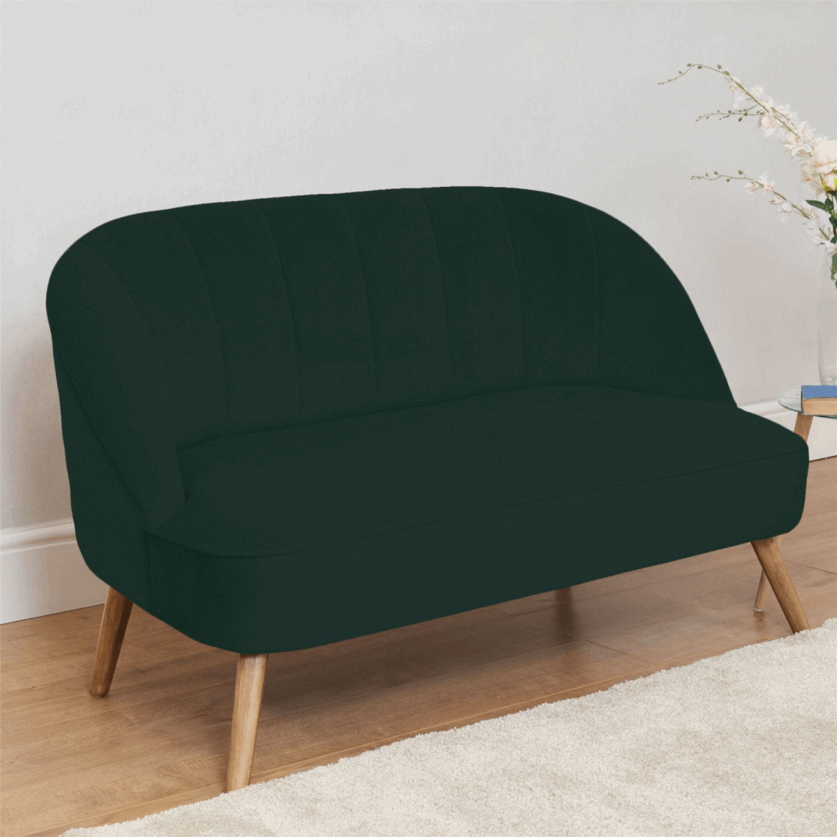 Widdop Two Seater Sofa in dark green with elegant curved design and wooden legs