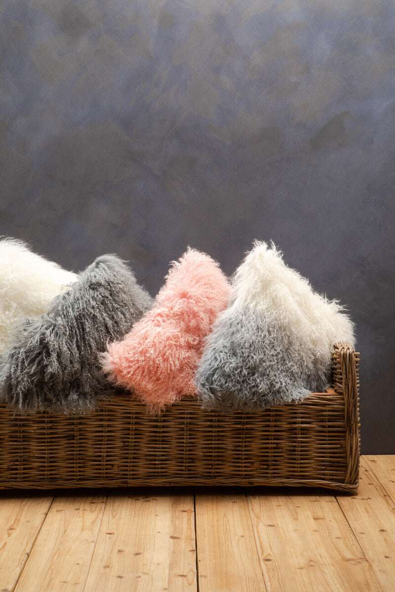 Orsina Square Cushion in various textures and colours arranged in a woven basket