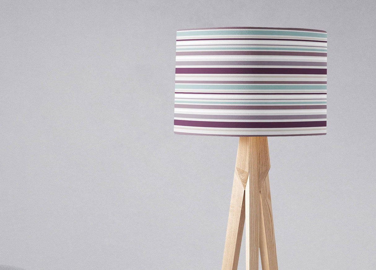 Shadow bright lampshade with multicoloured stripes on a wooden tripod lamp base