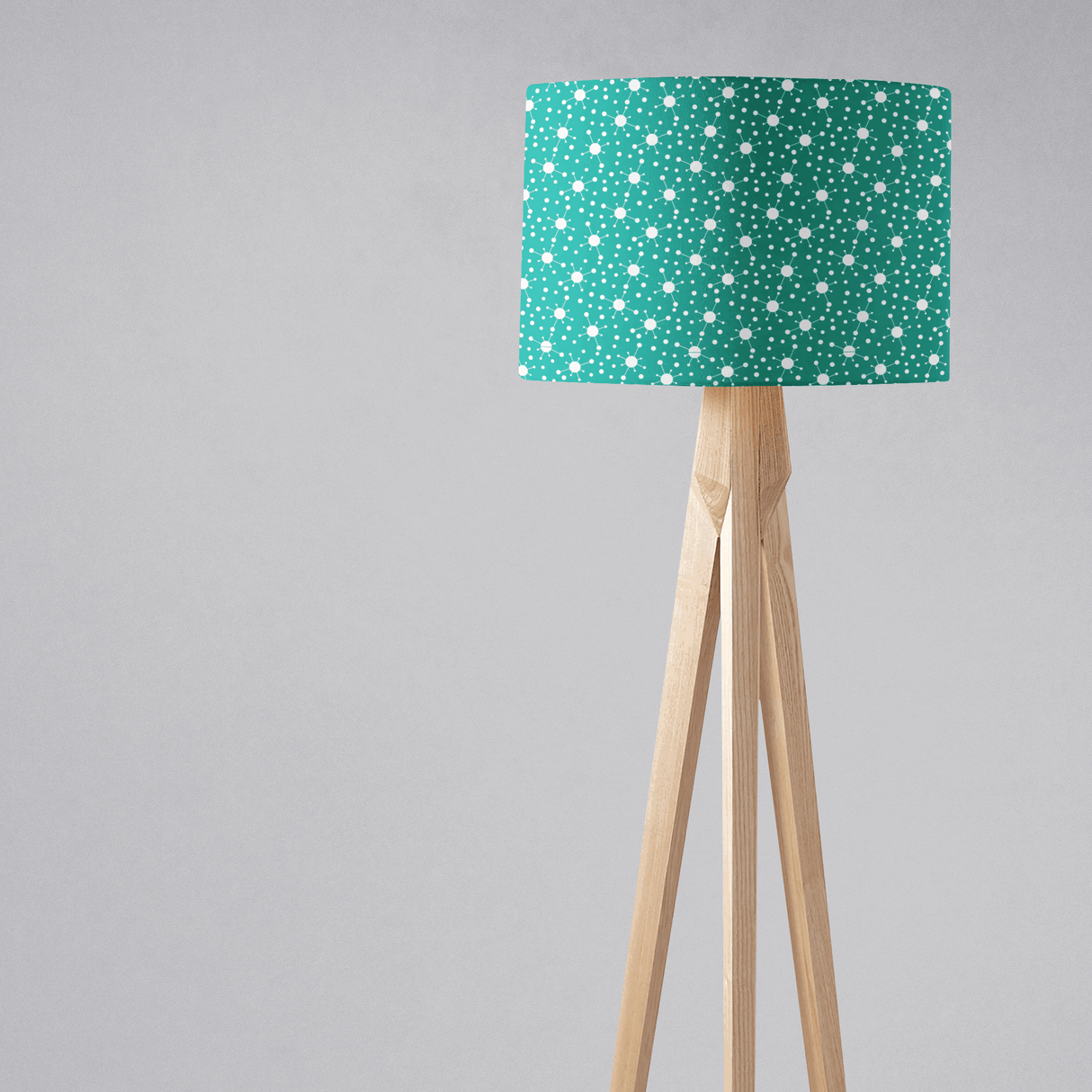 Shadow Bright Lampshade in teal with white polka dots on a wooden tripod lamp stand
