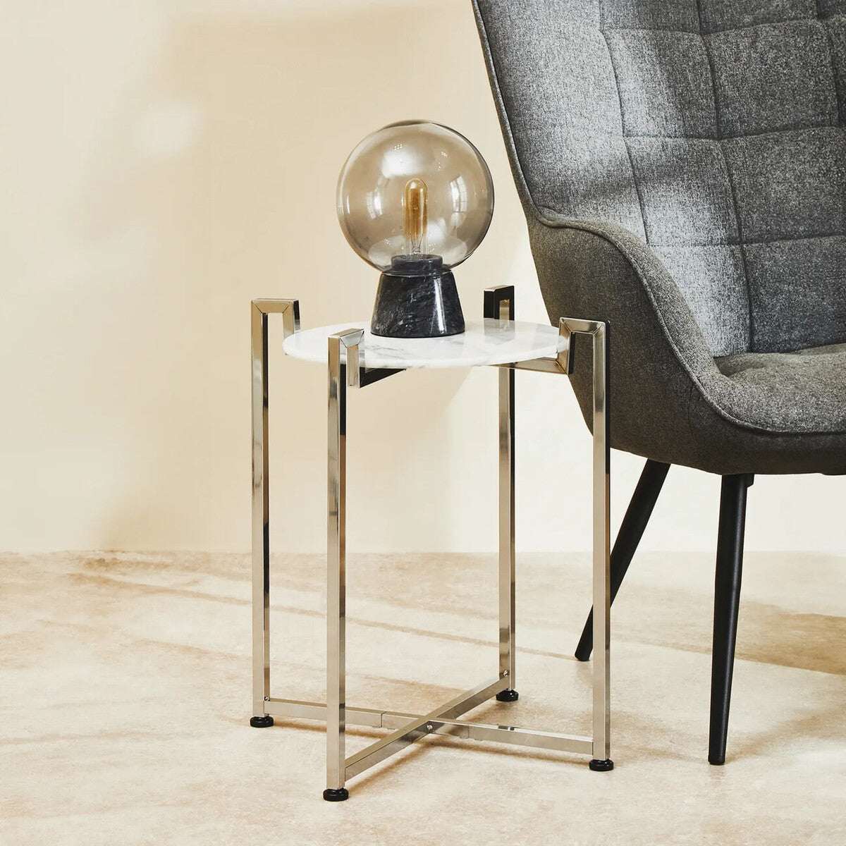 Orsina Side Table with a Marble Top and Modern Metal Frame beside a Stylish Armchair