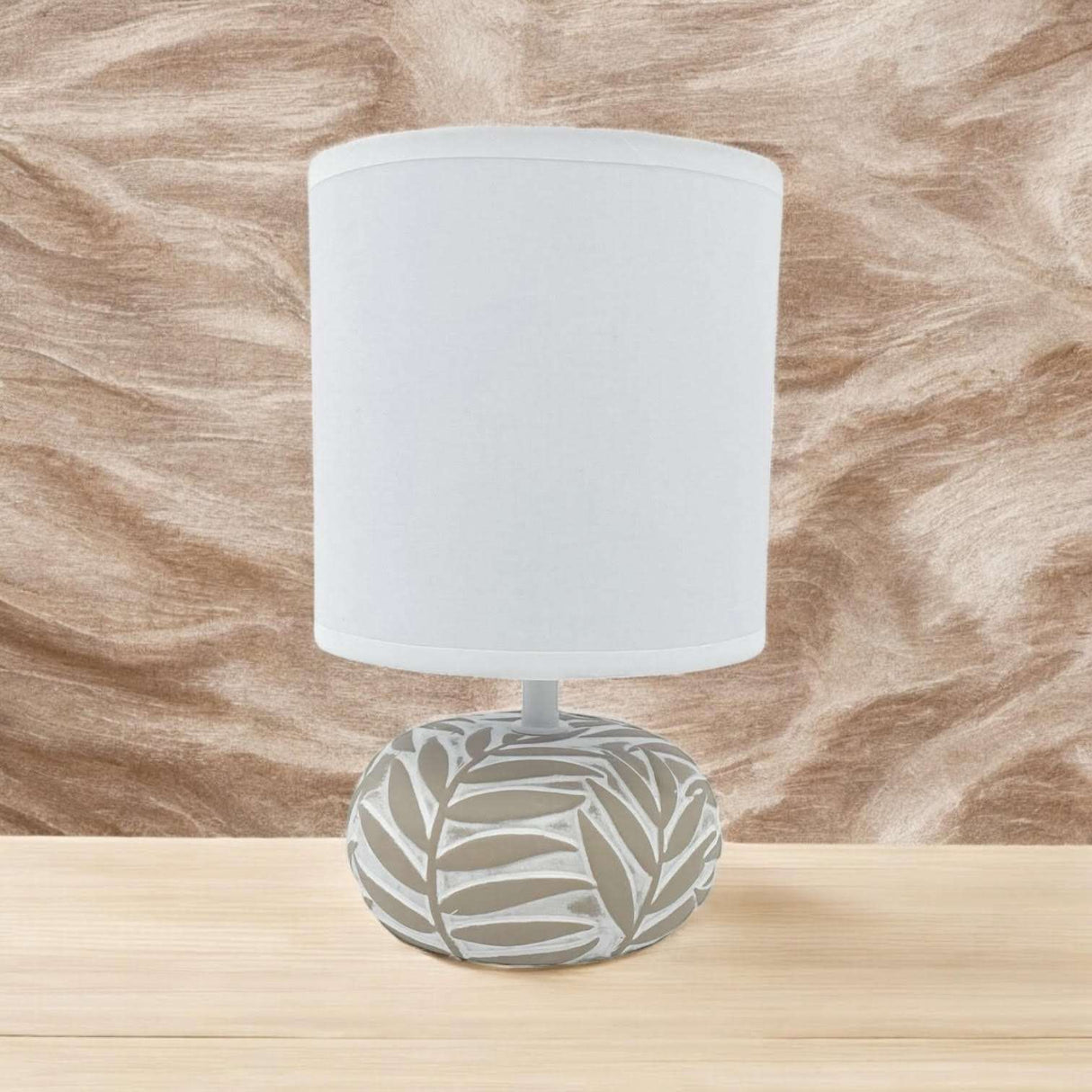 Stylish table lamp with a decorative leaf pattern base and a white shade for modern interiors