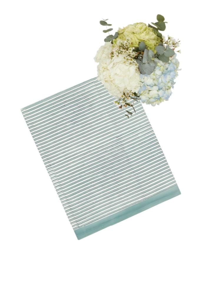 Casa by Josephine Jenno striped tablecloth in blue and white with a floral arrangement on top