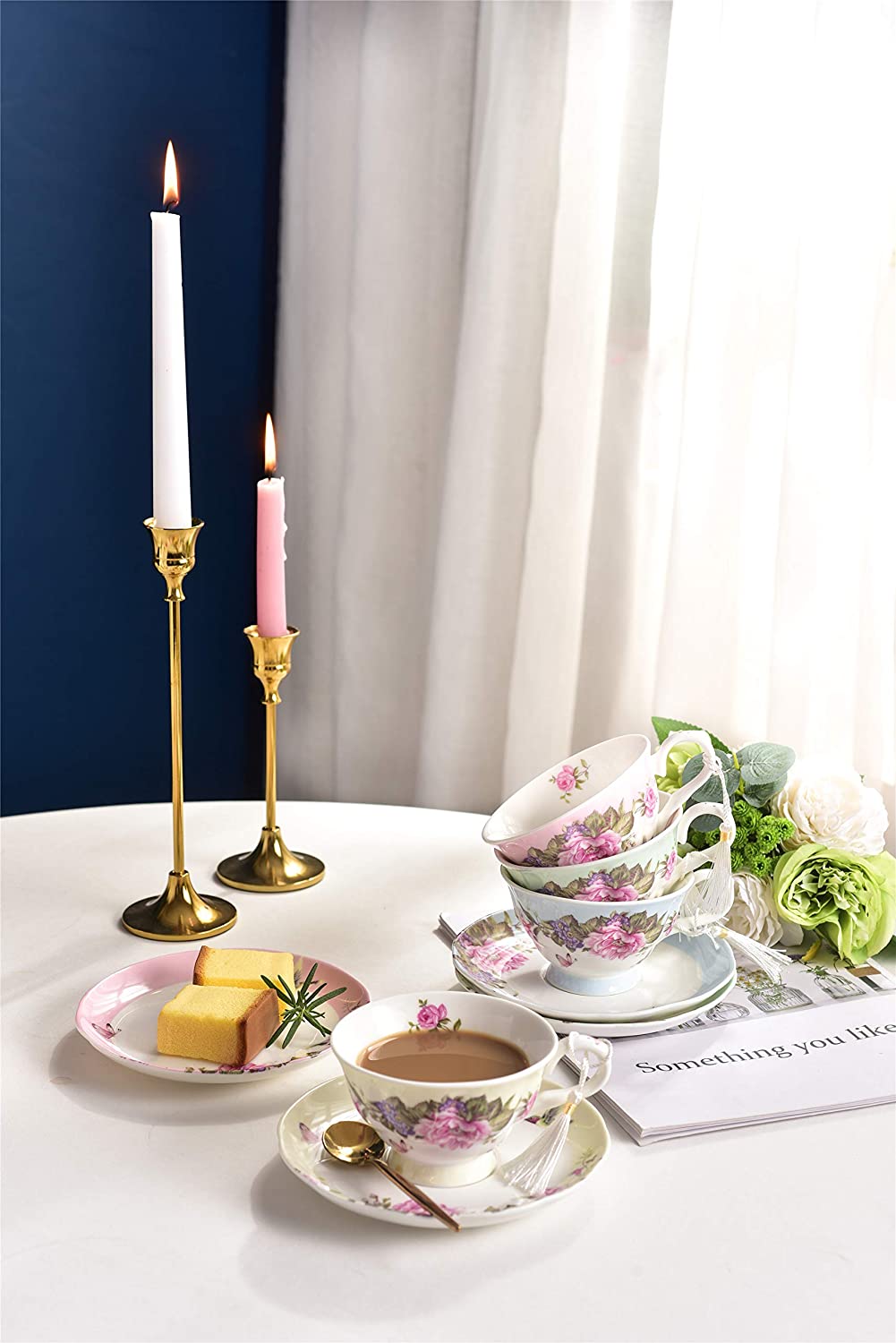 Elegant tea cups from London Boutique Lifestyle with floral design, serving cake and candles on a table