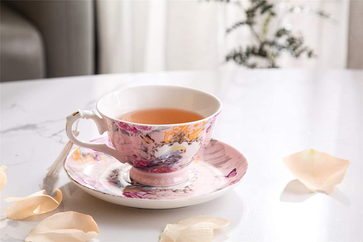 Elegant tea cup with floral design alongside a saucer, filled with herbal tea
