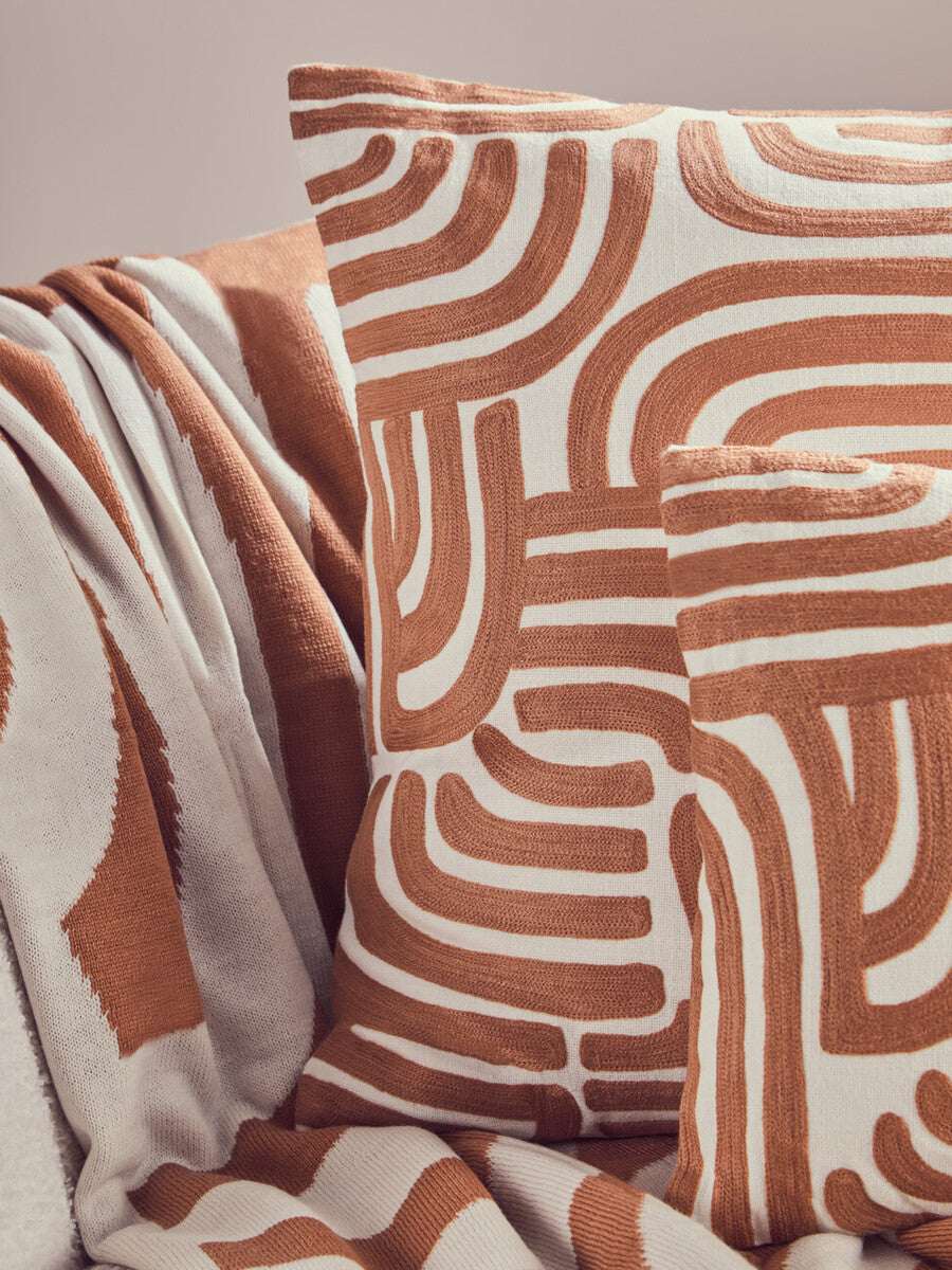 Orsina Terracotta Throw with Modern Abstract Pattern and Matching Cushions on Sofa
