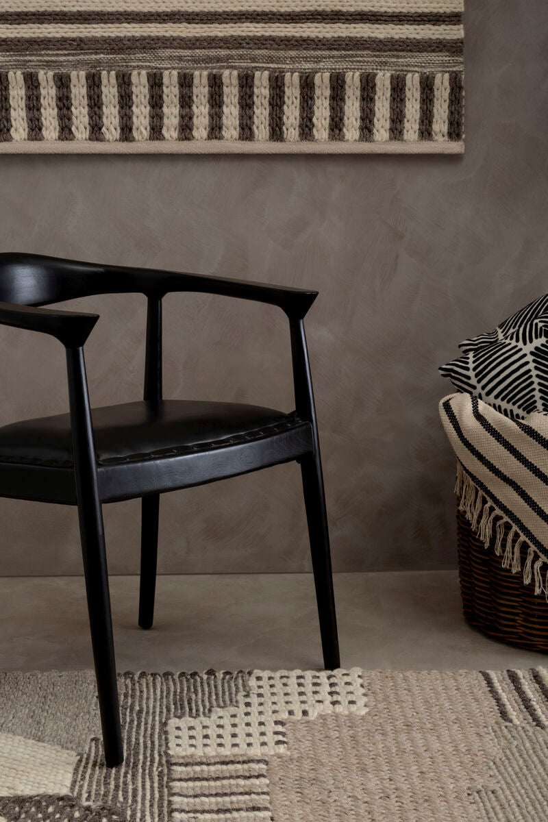 Orsina Textured Rug in neutral tones, complementing modern decor with a stylish chair and woven throw