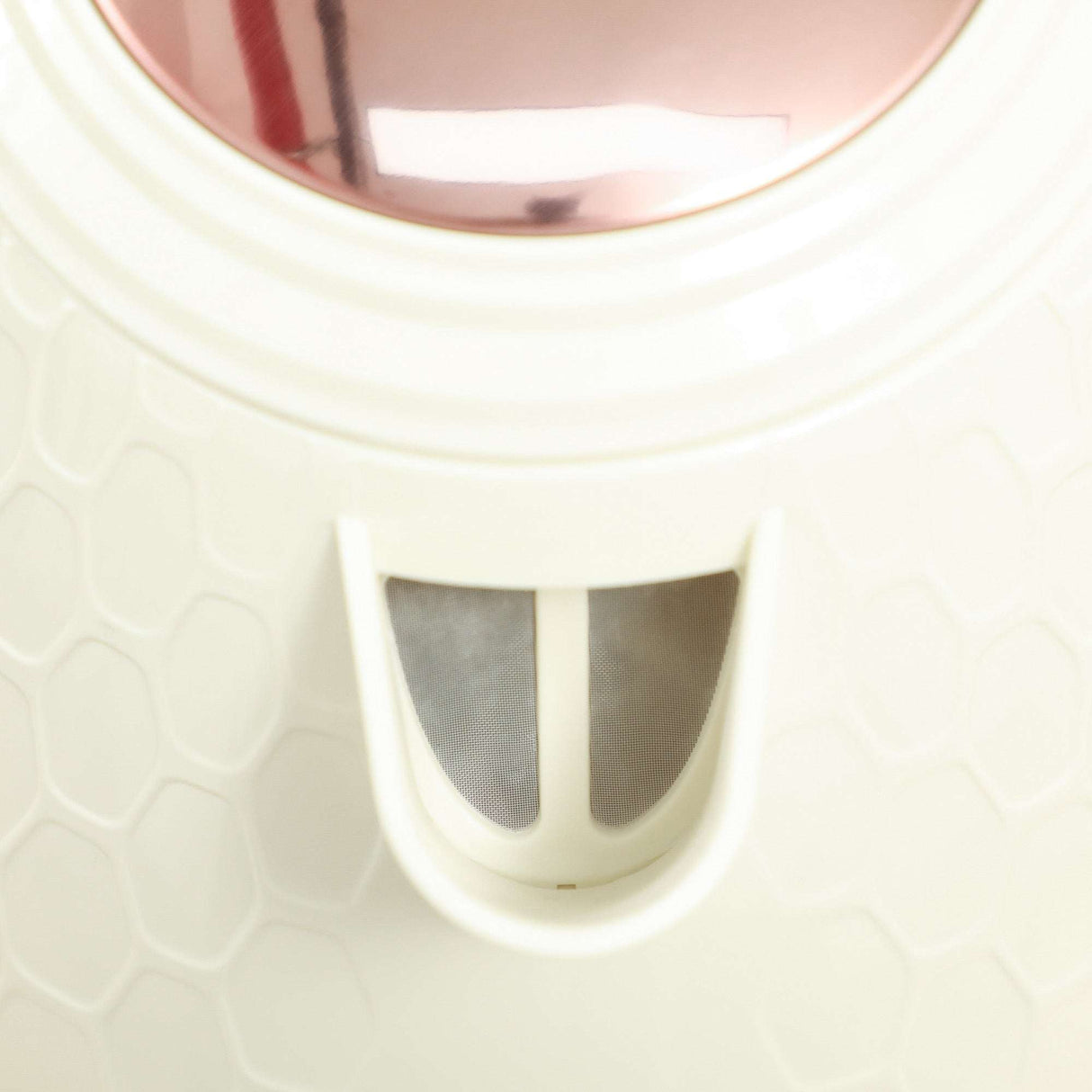 Close-up view of a stylish toaster set with a unique honeycomb design in ivory and rose gold