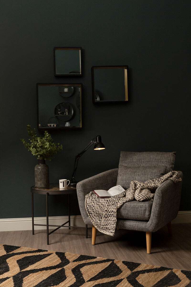 Stylish Orsina Hemp Rug placed under a modern armchair with a book and cozy blanket in a chic living space