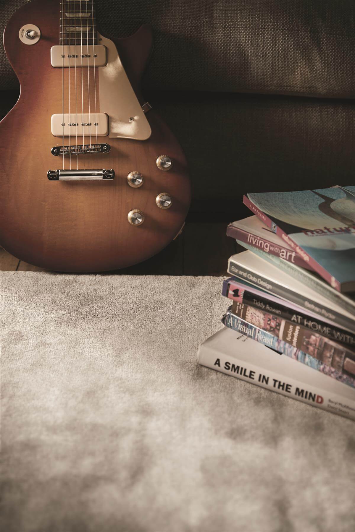 Soft Viscose Rug placed beside a stack of books and a guitar for a stylish living space