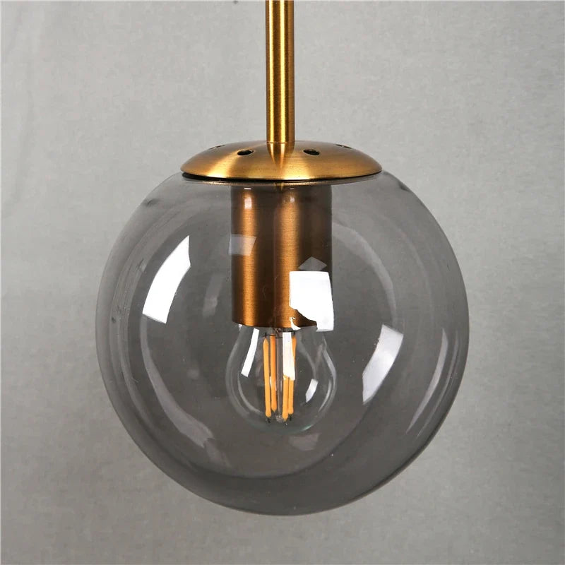 Stylish pendant Wall Light with a transparent globe and brass fixture for modern interiors