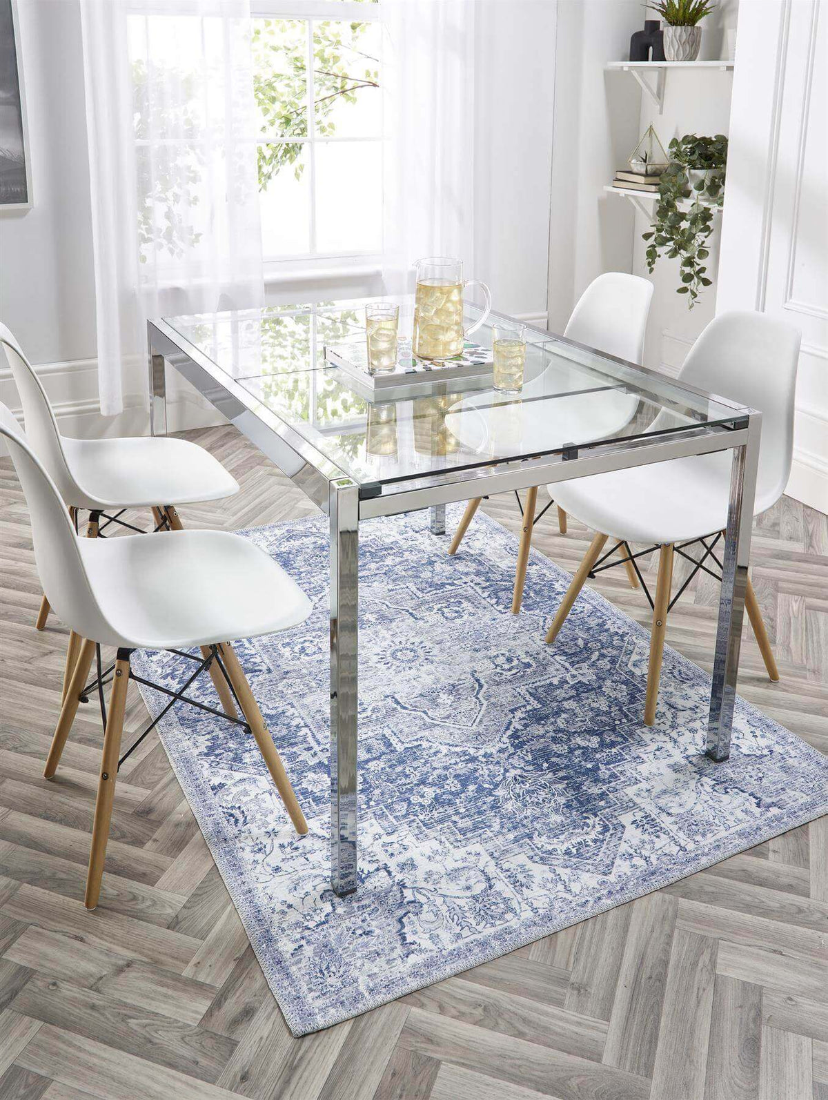 Elegant washable rug under a glass dining table with white chairs, adding style to modern interiors