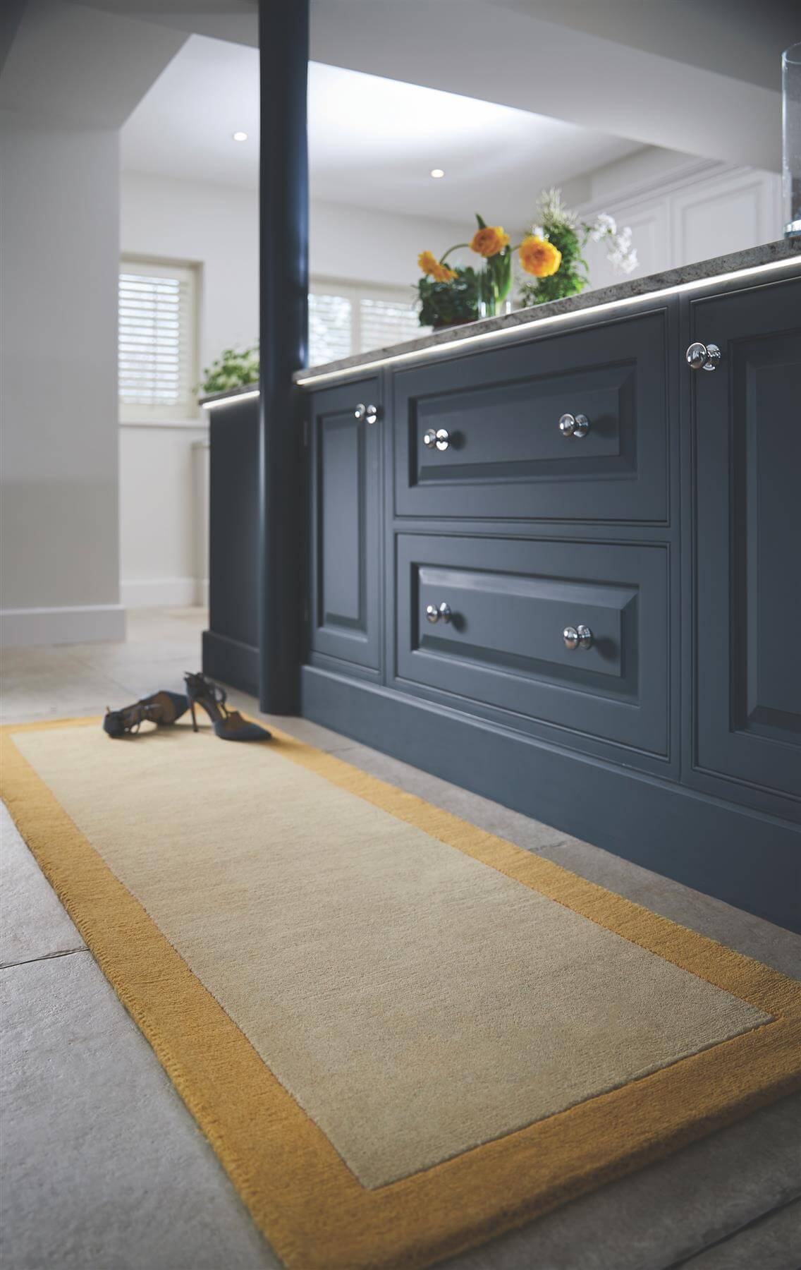Stylish wool rug in a kitchen, featuring a beige centre with a yellow border for elegant decor