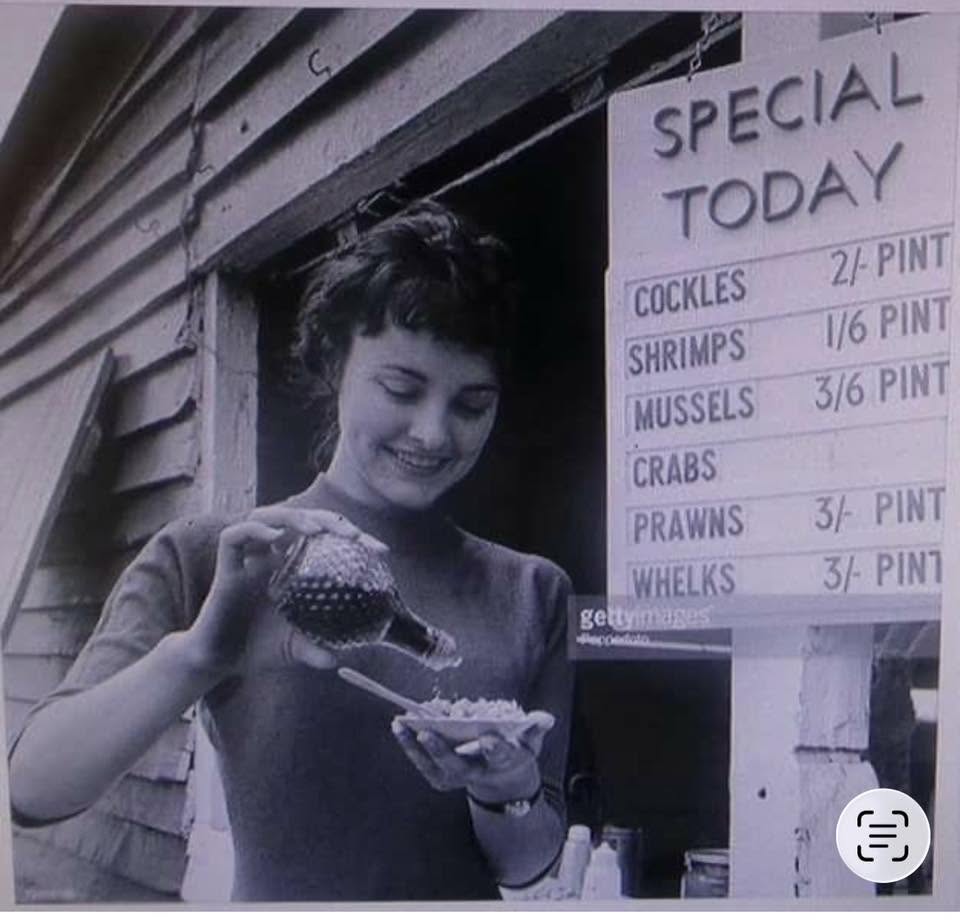 Vintage seafood stall at Shellshack serving seafood dishes like cockles and prawns to a smiling customer