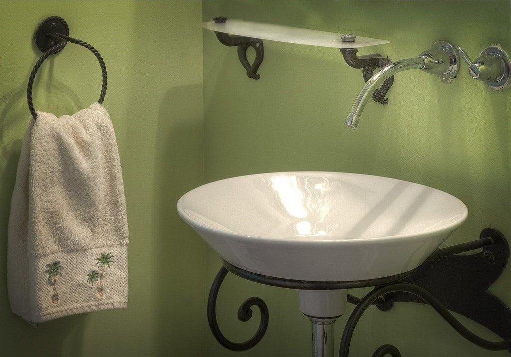 Stylish bathroom with a round white sink, wall-mounted faucet, glass shelf, and towel hanging on a ring