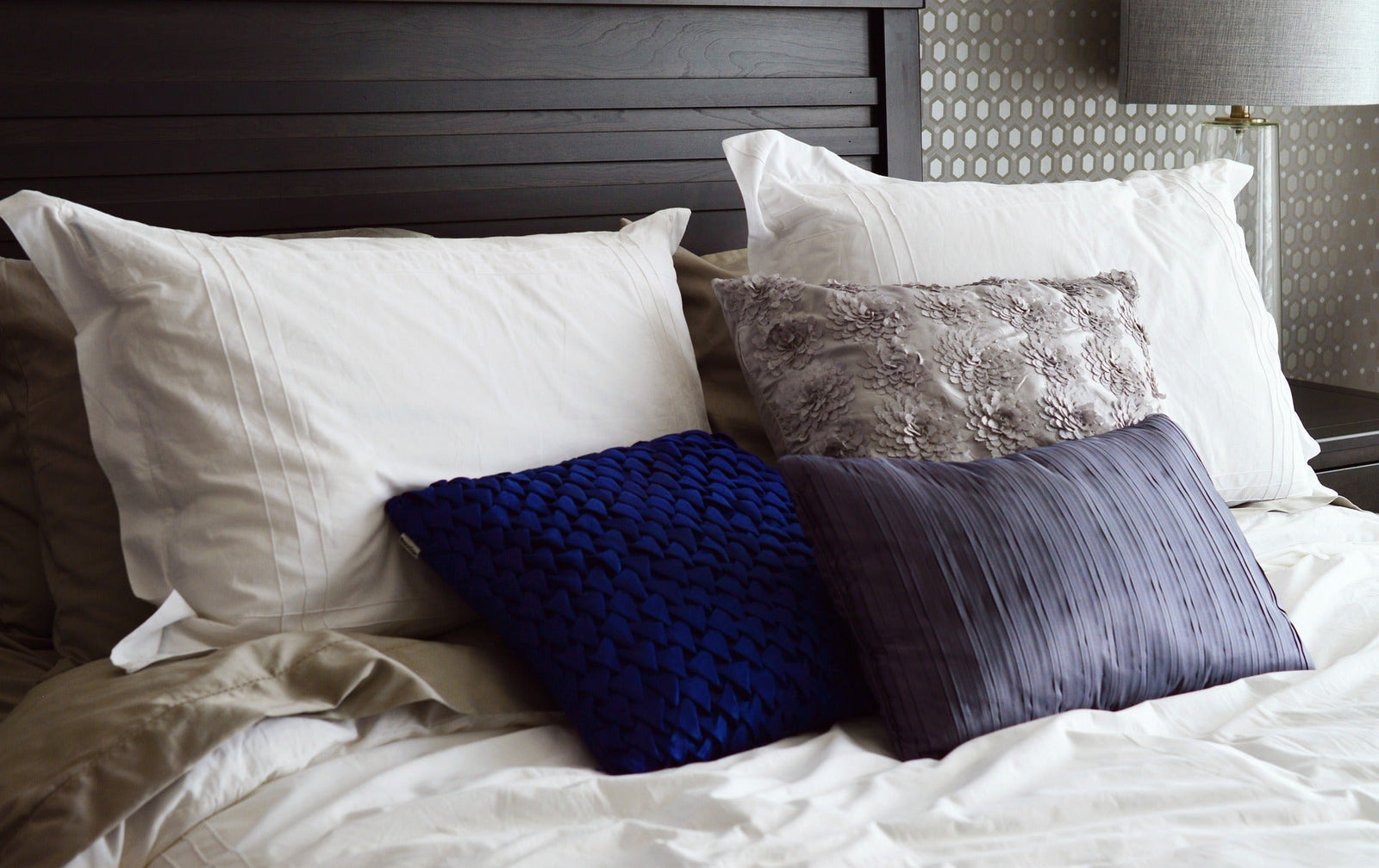 Stylish bedroom accessories including textured pillows arranged on a neatly made bed