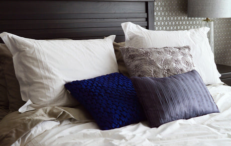 Stylish bedroom accessories including textured pillows arranged on a neatly made bed