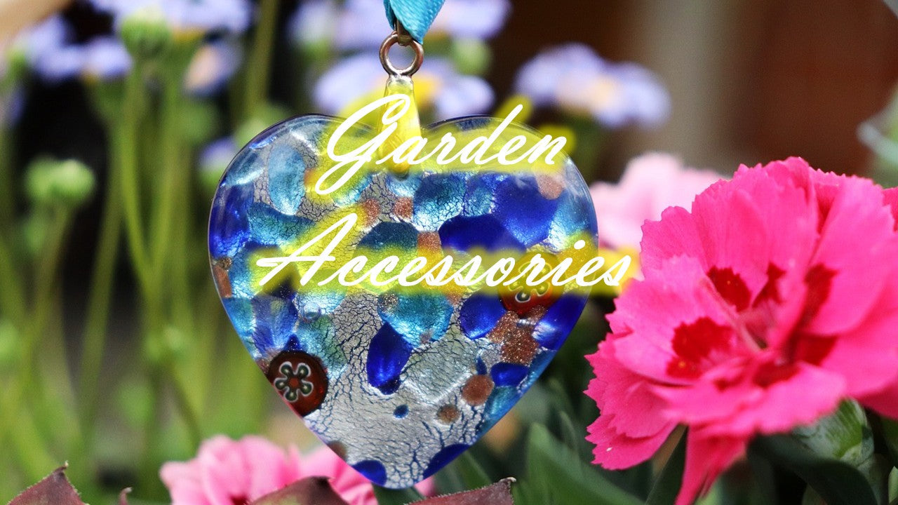 Beautiful glass heart ornament among vibrant flowers in a garden, showcasing unique garden accessories