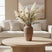 Amphora Vase on a wooden coffee table with dried flowers, enhancing a modern living room decor