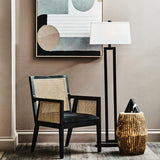 Orsina Arm Chair in black and natural rattan with modern decor and floor lamp