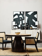 Orsina Arm Chair in rattan style beside a round table and modern art decor