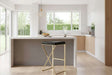 Orsina Bar Stool with a sleek black seat and a stylish gold frame in a modern kitchen setting