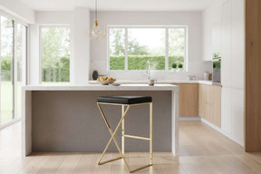 Orsina Bar Stool with a sleek black seat and a stylish gold frame in a modern kitchen setting