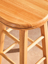 Orsina Bar Stool made of natural wood with a smooth, rounded top and sturdy legs