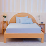 SHEET STORY Bedding Set in light blue, featuring a fitted sheet and pillowcases on a wooden bed frame