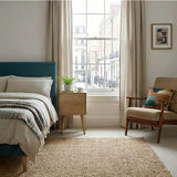 Fishe and Lilly bedside table with rounded edges next to bed in a modern bedroom setting