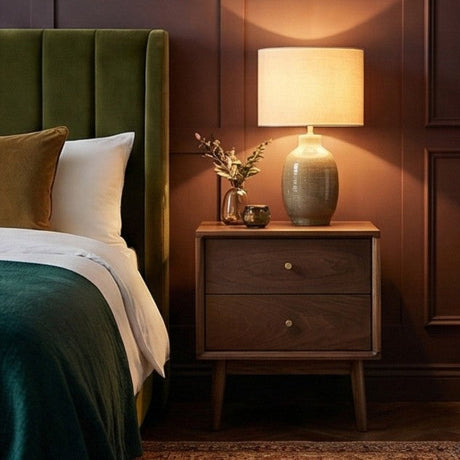 Stylish Fishe and Lilly bedside table with two drawers, lamp, and decorative plant in a modern bedroom setting