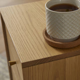 Stylish Fishe and Lilly bedside table with a cup of coffee on top, showcasing its wooden finish