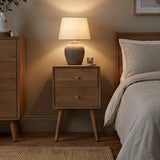 Fishe and Lilly wooden bedside table with a lamp and soft ambient lighting in a cosy bedroom setting