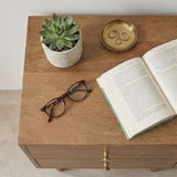 Stylish bedside table with a succulent plant, eyeglasses, a book, and decorative items