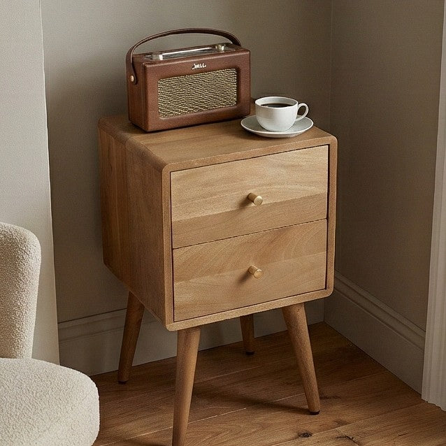 Fishe and Lilly wooden bedside table with two drawers, coffee cup, and radio on top