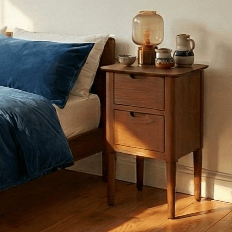 Fishe and Lilly wooden bedside table with two drawers beside a bed featuring blue bedding