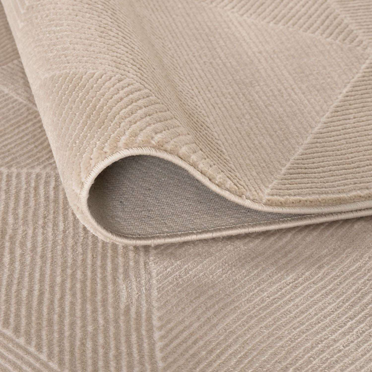 Close-up of a soft textured beige rug with a modern geometric pattern