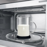 Bialetti Milk Frother heating milk in microwave with clear glass pitcher and black base