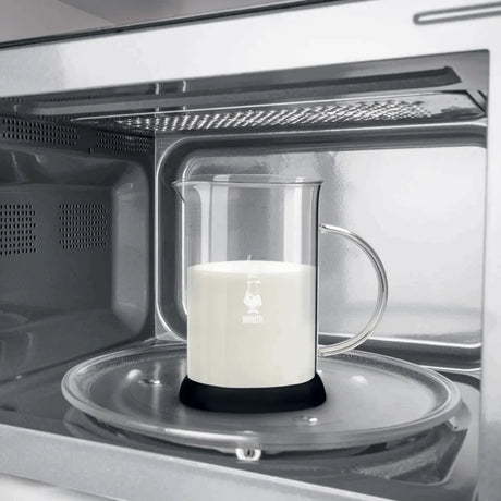 Bialetti Milk Frother heating milk in microwave with clear glass pitcher and black base