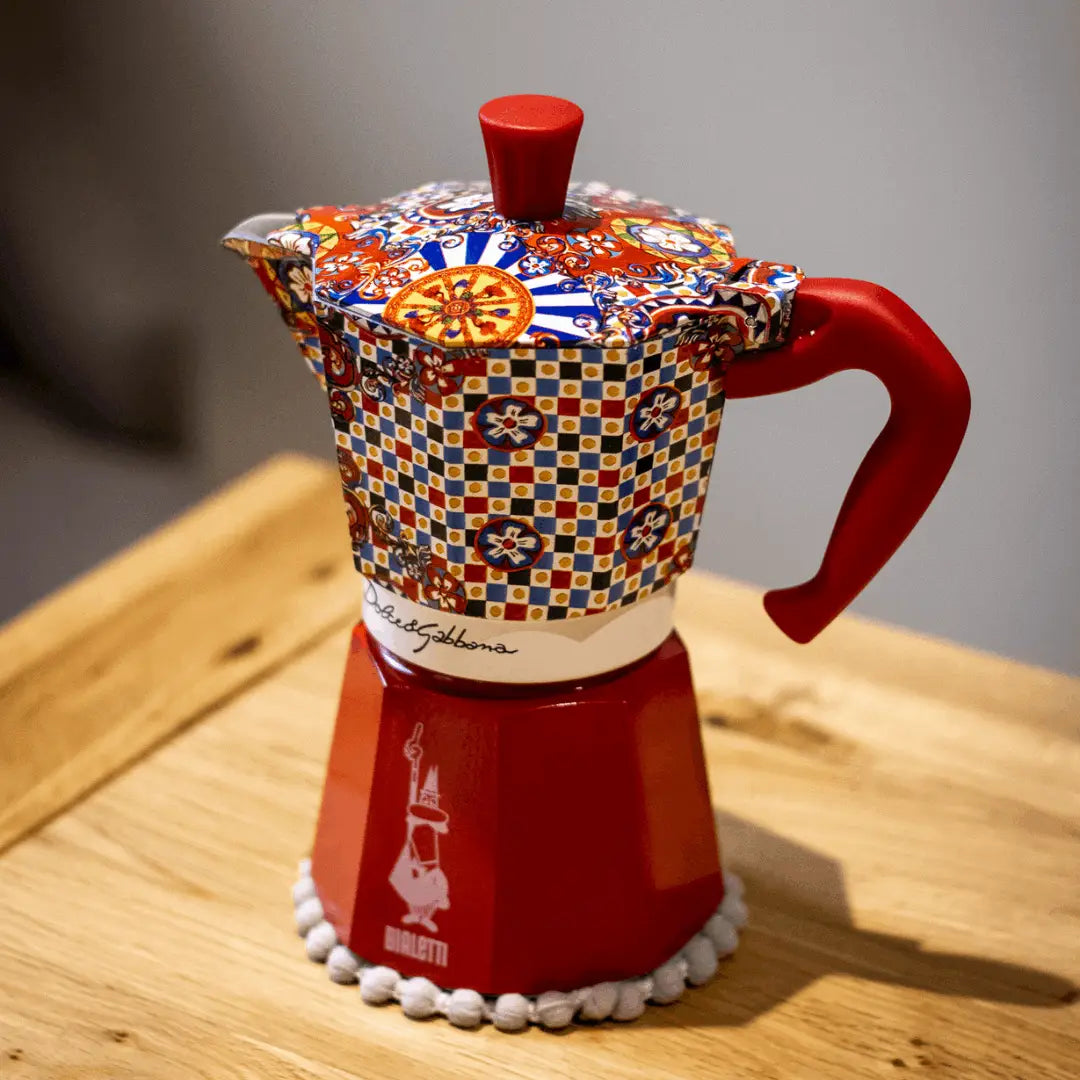 Bialetti Moka Express coffee maker with vibrant patterned lid and red base, perfect for brewing espresso