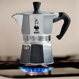 Bialetti Moka Express stovetop coffee maker on a gas burner for brewing espresso at home