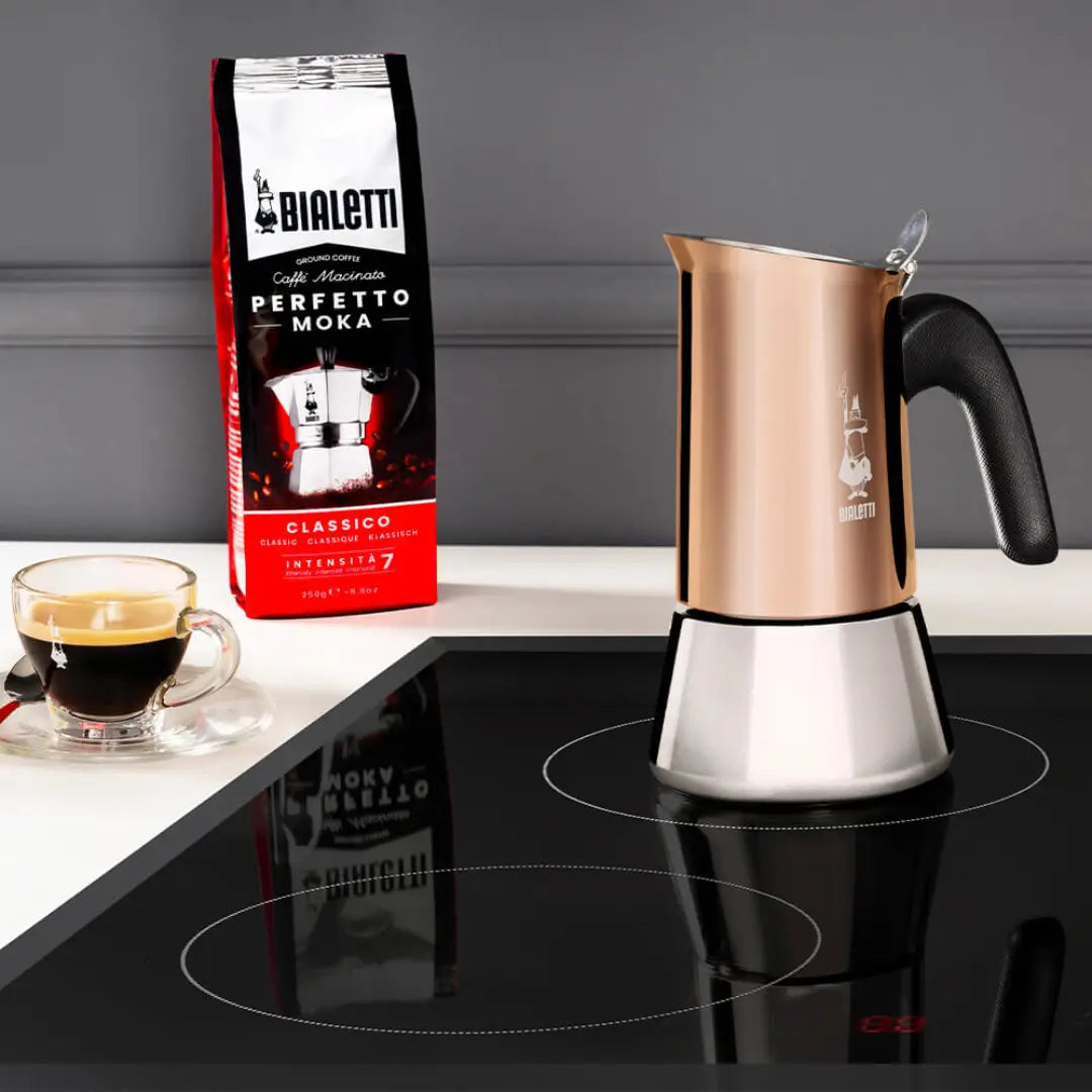 Bialetti Moka Coffee Maker in copper and stainless steel with coffee cup and beans in the background
