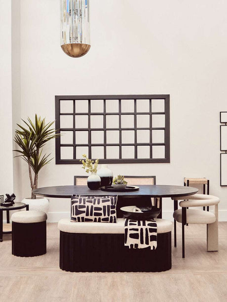 Stylish black throw draped over a patterned cushion in a modern dining setting