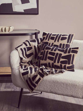Orsina Black Throw draped over a cosy sofa with patterned cushions for stylish home decor