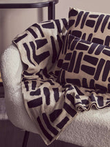 Orsina Black Throw on a cosy chair with patterned cushions for stylish home decor