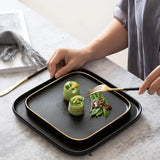 Elegant Blino Plates by Nisu Home featuring a black design and gold trim, perfect for stylish dining