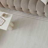 Light-coloured Bordered Rug placed under a plush sofa, enhancing modern home decor