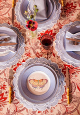 Casa by Josephine Jenno tablecloth featuring a vibrant red floral design with matching plates and cutlery